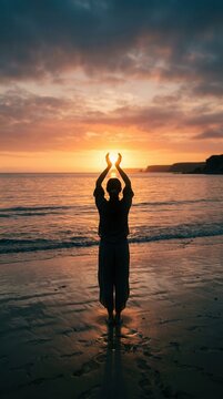 Silhouette of a person standing on a beach at sunset, holding the sun between their hands