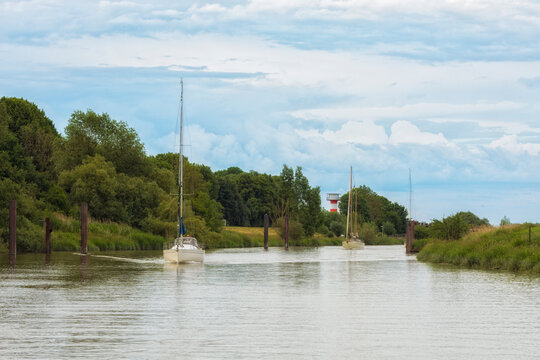 Sailboats on Schwinge river heading to Stade, Lower Saxony, Germany
