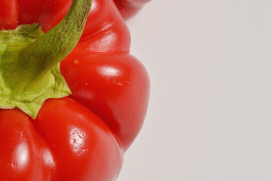Close up red bell pepper border composition against clean white background with generous copy space, red pepper culinaary overlay, pepper photo for branding
