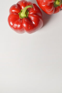 Red bell pepper top down border composition against clean white background with generous copy space, red pepper culinary overlay, pepper photo for branding