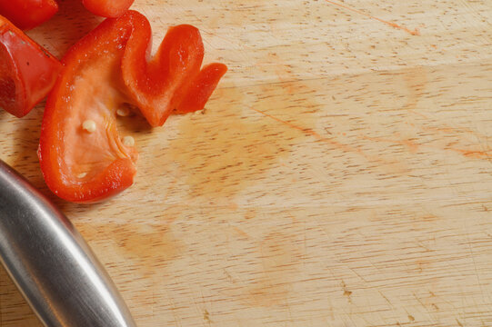 chopped red bell pepper and silver knife against wooden chopping board with generous copy space, red pepper culinary overlay, pepper photo for branding