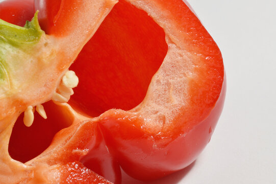 cut in half  red bell pepper and silver knife against clean white background with generous copy space, red pepper culinary overlay, pepper photo for branding