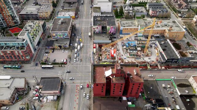 Ongoing Broadway Line SkyTrain Construction With Cranes, Traffic, and City Buildings - Main Street to Cambie Street, Vancouver, Canada - Aerial Drone Shot