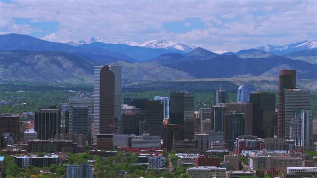 Mile High City of Denver Front Range snow-capped Rocky Mountains landscape skyscraper skyline cityscape buildings downtown Denver Colorado drone aerial Spring morning bluesky clouds circle left motion