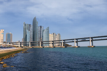 Obraz premium Scenic view of Gwangan Bridge and Marine City modern skyscraper skyline with blue sea in Busan, South Korea.
