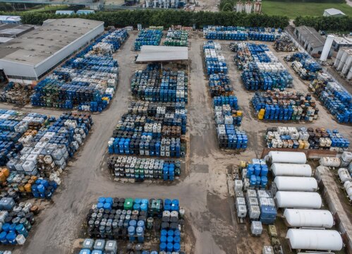 Industrial facility storing chemical drums and oil barrels in open yard