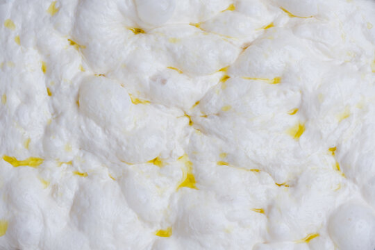 Naturally fermented sourdough focaccia dough during the final proofing stage. The dough surface is filled with air bubbles artisan bread-making process and traditional natural leavening techniques.