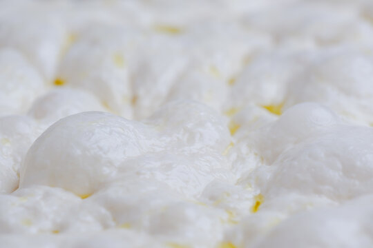Naturally fermented sourdough focaccia dough during the final proofing stage. The dough surface is filled with air bubbles artisan bread-making process and traditional natural leavening techniques.