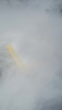 Lithium-ion pouch battery emits thick white smoke against a dark background. Intense close-up captures the dramatic vapor, suggesting a science experiment or technological failure.