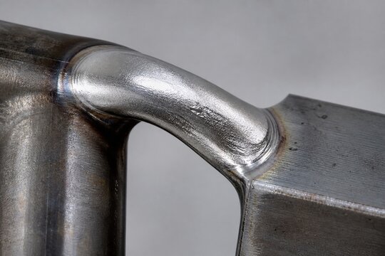 A smooth, silvery arc of solidified braze material on a metal joint.