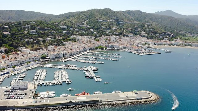 Drone view of Port de la Selva, a charming fishing village on the Costa Brava, featuring its harbour, whitewashed houses and the surrounding Cap de Creus landscape. 