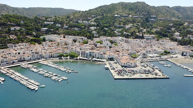Drone view of Port de la Selva, a charming fishing village on the Costa Brava, featuring its harbour, whitewashed houses and the surrounding Cap de Creus landscape. 