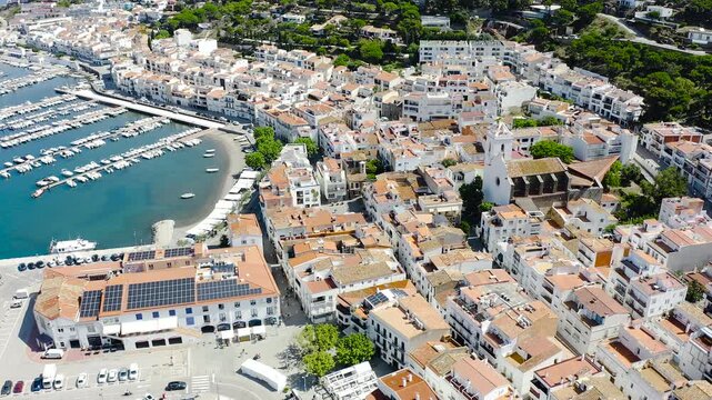 Drone view of Port de la Selva, a charming fishing village on the Costa Brava, featuring its harbour, whitewashed houses and the surrounding Cap de Creus landscape. 