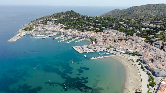 Drone view of Port de la Selva, a charming fishing village on the Costa Brava, featuring its harbour, whitewashed houses and the surrounding Cap de Creus landscape. 
