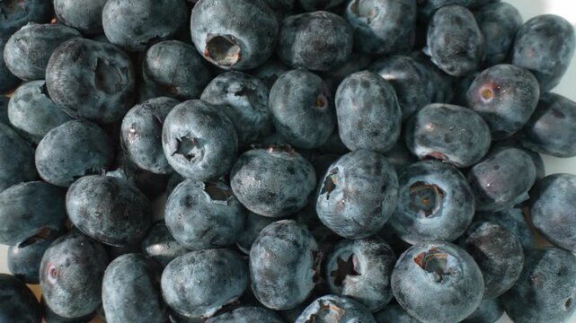 Close-up view of fresh blueberries showcasing their natural texture, deep blue color, and juicy appearance, highlighting a healthy fruit rich in antioxidants and perfect for nutritious food concepts.
