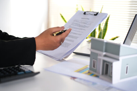 staff is explaining the information about the house lease contract documents to the buyer, the buyer signs the house lease agreement acknowledgment contract with the staff to transfer the ownership

