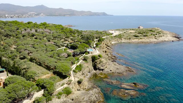 Aerial view of La Vall Beach, the main urban beach of Port de la Selva, with golden sand, calm Mediterranean waters and the village waterfront. 