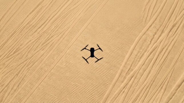 A black drone is positioned on a textured wooden surface. The drone is centered in the frame, and the wood grain creates a visually interesting background.