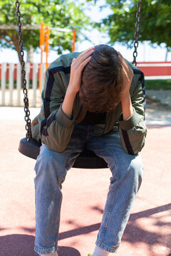 Lonely teenager swinging alone outdoors