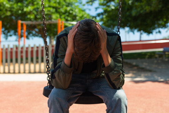 Lonely teenager swinging alone outdoors
