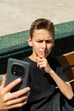 Teenager waving hand saying hello on the phone outdoors