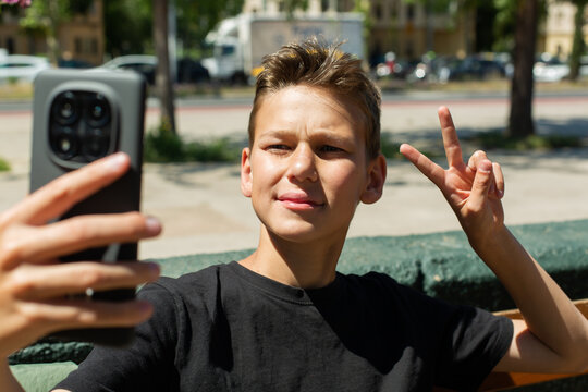 Teenager waving hand saying hello on the phone outdoors