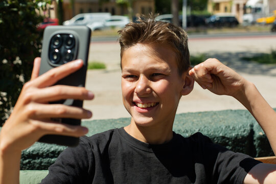 Teenager waving hand saying hello on the phone outdoors