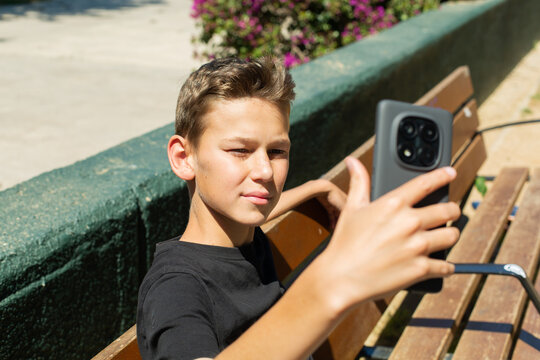 Teenager waving hand saying hello on the phone outdoors