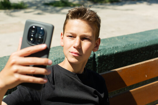 Teenager waving hand saying hello on the phone outdoors