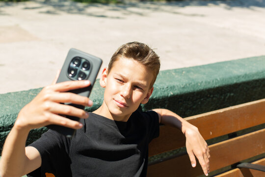 Teenager waving hand saying hello on the phone outdoors