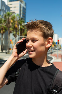 Teenager looking to his phone sitting outdoors