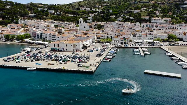 Drone view of Port de la Selva, a charming fishing village on the Costa Brava, featuring its harbour, whitewashed houses and the surrounding Cap de Creus landscape. 