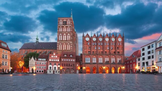 Stralsund, Germany - Alter Markt square at dusk with historic Town Hall and church of St. Nikolai (static image with animated sky)