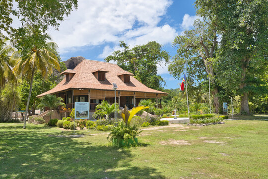 La Digue, Seychelles, 01.06.2026, Beautiful view of the historic Grand Kaz colonial heritage plantation house at L'Union Estate, featuring a garden fountain and national flag under a blue sky