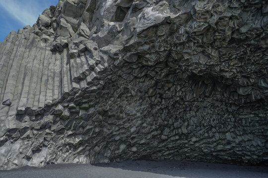 Columnar basalt rock formation with hexagonal columns and rugged cliff face,ICELAND