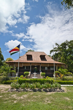 La Digue, Seychelles, 01.06.2026, Beautiful view of the historic Grand Kaz colonial heritage plantation house at L'Union Estate, featuring a garden fountain and national flag under a blue sky