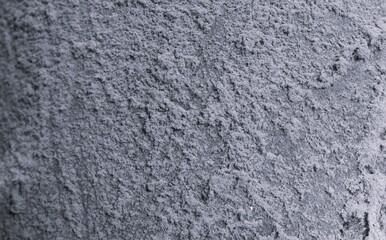 Fototapeta premium Monochrome close-up of powdery concrete wall texture with soft granular patches, shallow focus, dusty scratches, and worn industrial background.