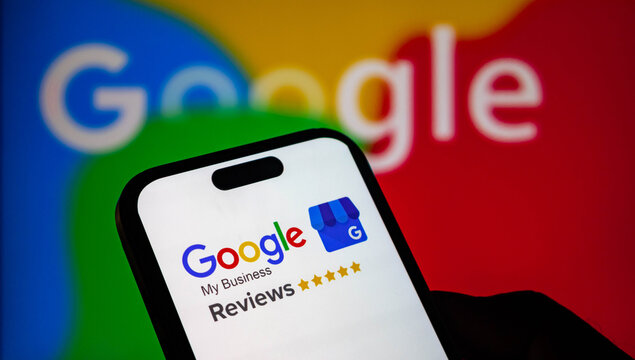 Closeup of a smartphone screen displaying the google my business reviews logo with five gold stars