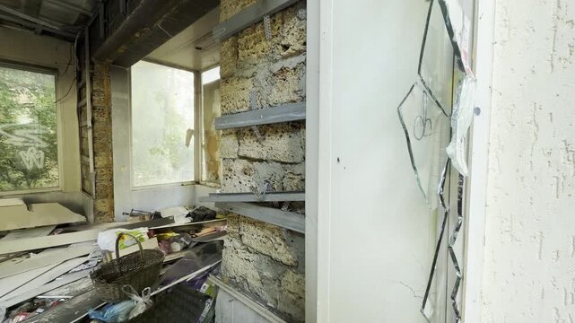Heavy debris and shattered glass clutter a ruined indoor room. This desolate scene brings a sad feeling of total neglect. The empty space looks completely hopeless.