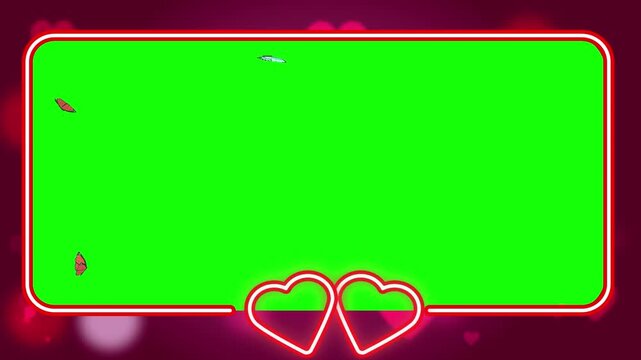 Neon frame shaped like two interlocking hearts encloses a vibrant green screen area to provide a perfect space for custom video messages or romantic content creation during festive holiday seasons.