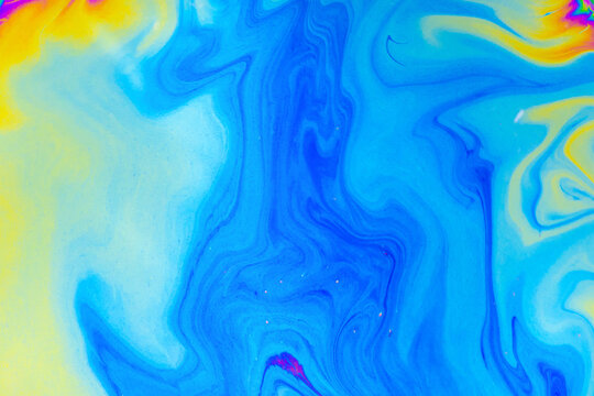 Abstract fluid paint background with blue yellow and orange swirl texture