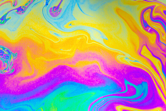 Abstract fluid color pattern with yellow pink blue and purple swirls on bright marbled background