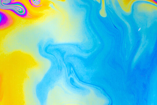 Abstract colorful fluid paint swirl yellow blue gradient texture pattern