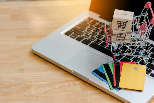 Online shopping cart laptop with credit card and ecommerce payment on wooden desk