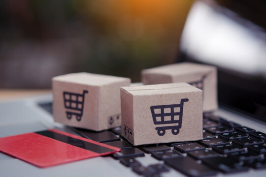 Shopping online. Credit card and cardboard box with a shopping cart logo on laptop keyboard. Shopping service on The online web. offers home delivery