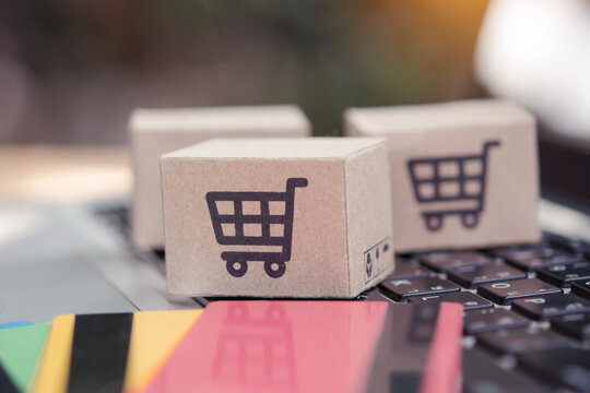 Shopping online. Credit card and cardboard box with a shopping cart logo on laptop keyboard. Shopping service on The online web. offers home delivery
