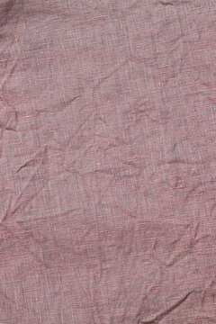 Fabric texture showing a wrinkled surface in a neutral color during daylight hours