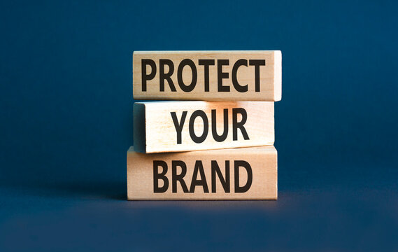 Protect your brand words symbol. Concept words Protect your brand on beautiful wooden blocks. Beautiful grey background. Business and protect your brand concept. Copy space.