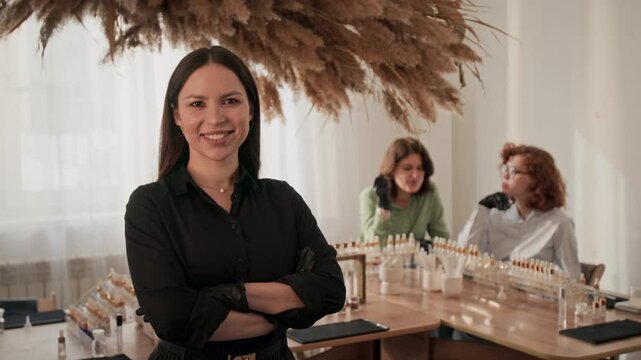 Portrait of Caucasian young adult woman perfumer smiling with arms crossed during workshop. Video is perfect for promoting beauty masterclasses and artisanal fragrance creation courses
