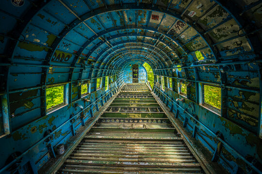 View of the derelict interior of an abandoned aircraft fuselage with peeling blue paint and exposed metal ribs at the historic Zeljava Aerodrome Zeljava, Licko-senjska, Croatia.